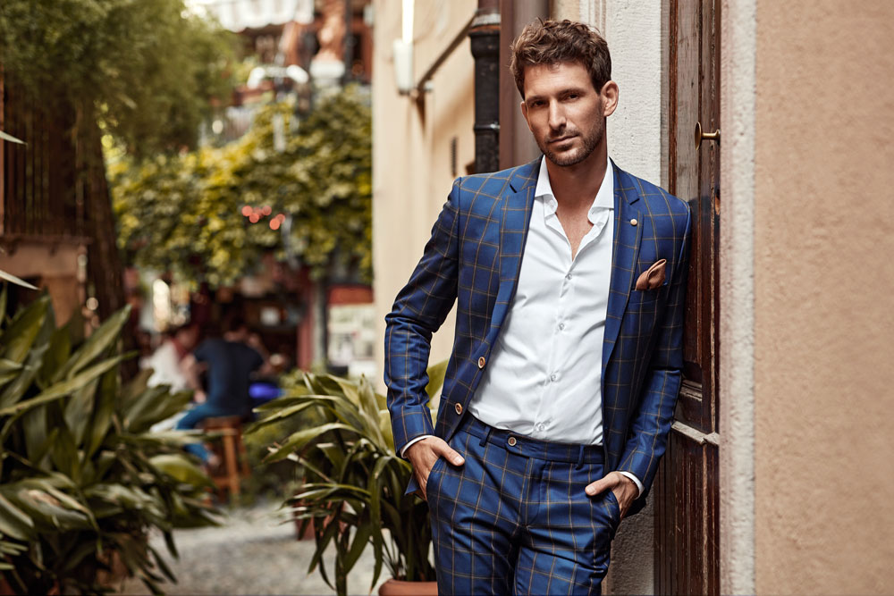 Eleganter Mann in blauem Anzug blickt in die Kamera